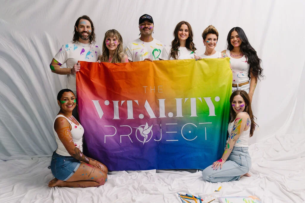 Vitality Project members holding a rainbow flag