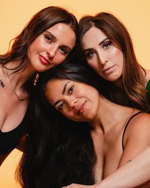 Three beauty professionals leaning in together