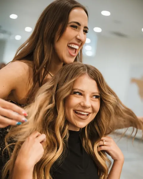 Two beauty professionals laughing together