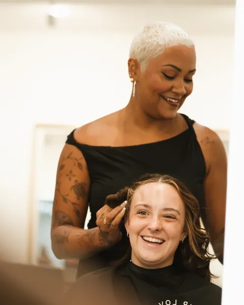 A stylist with a smiling client in a salon suite