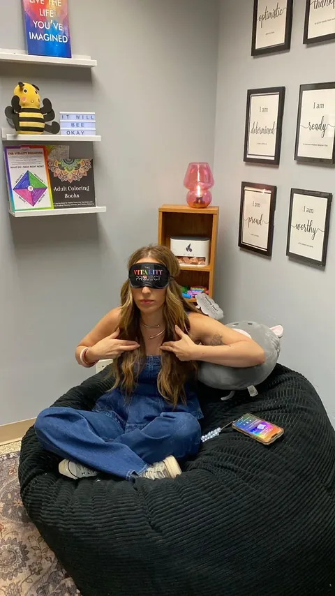 A student resting in the Vitality Pod wearing a Vitality Project eye mask