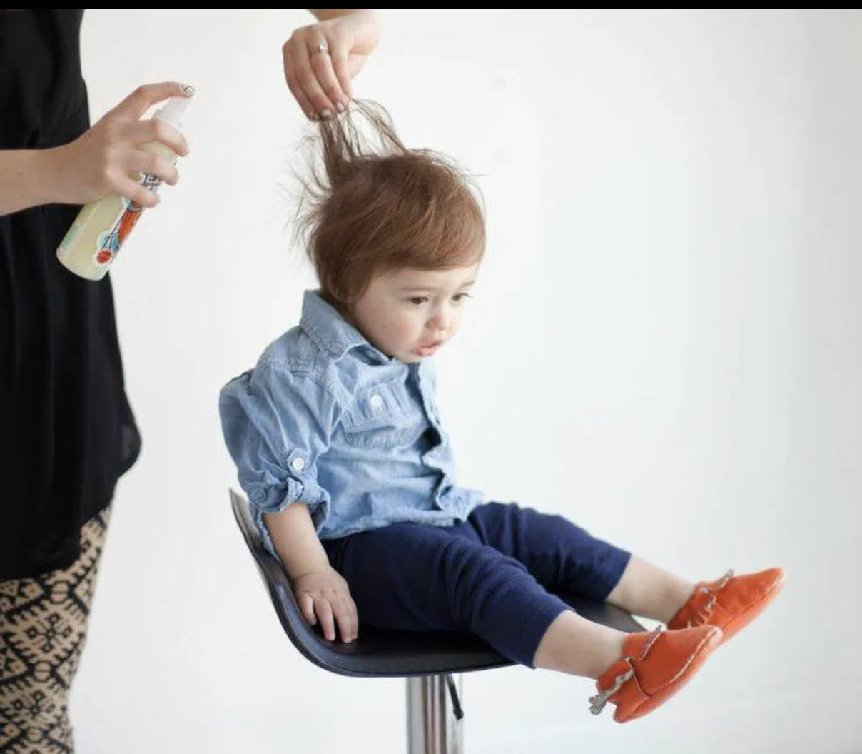 Elizabeth Faye's son in the salon chair getting his hair spritzed