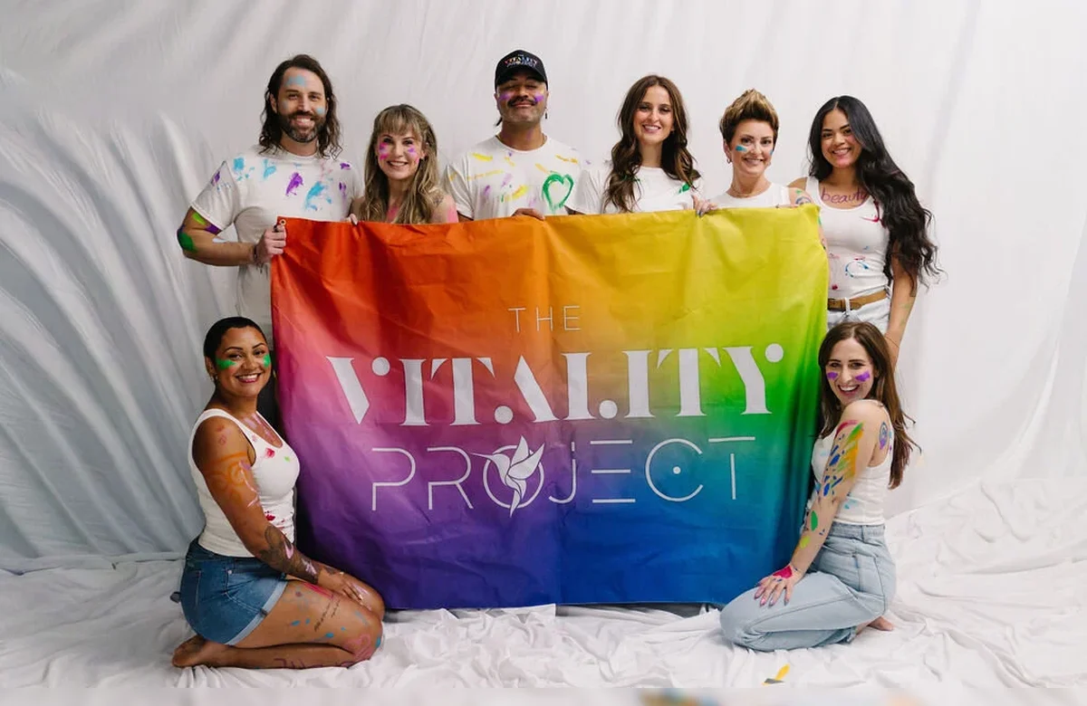 The Vitality Project team holding the rainbow flag