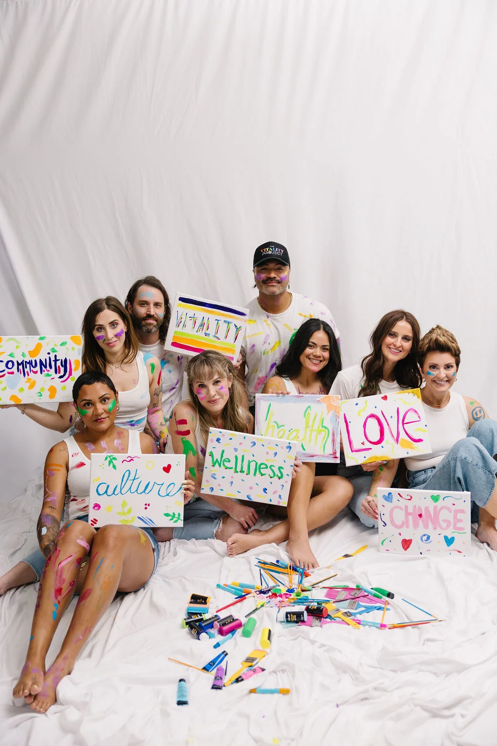 The Vitality team painting signs — community, culture, wellness, love, change
